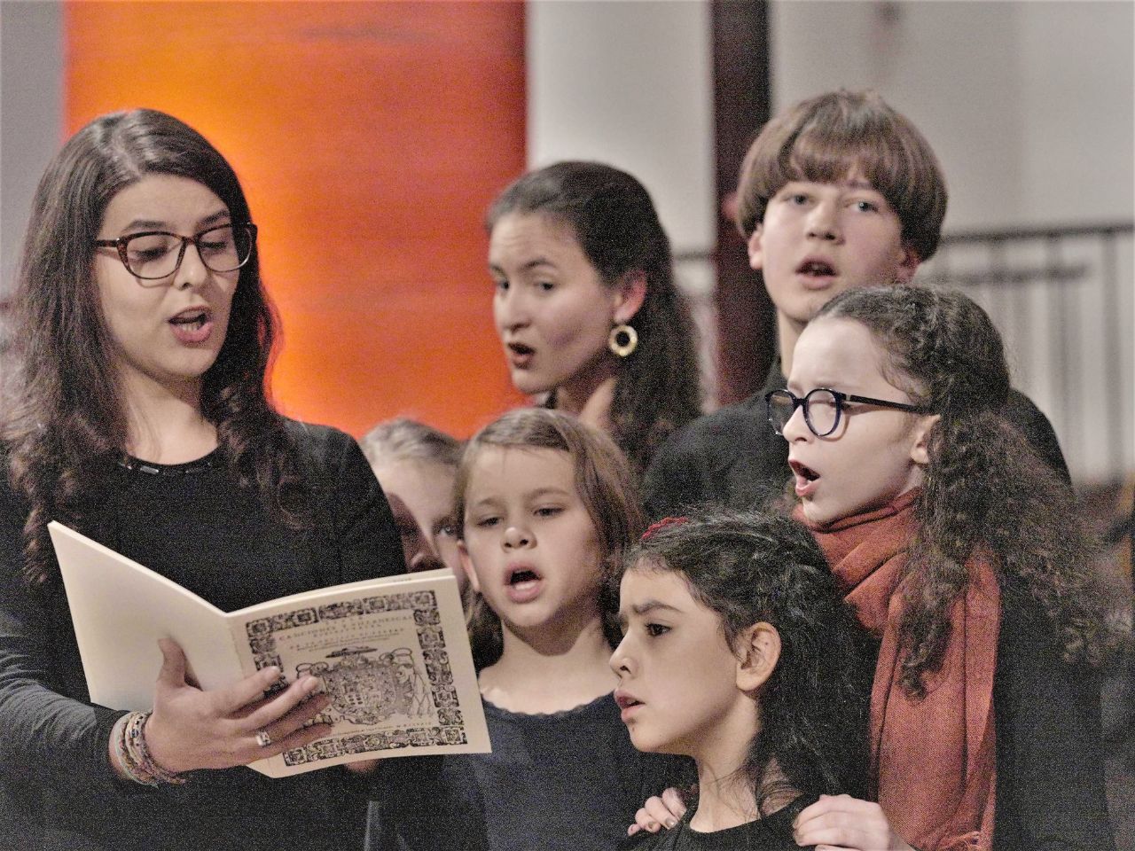 Gruppe von Kindern und jungen Frauen beim Chorsingen