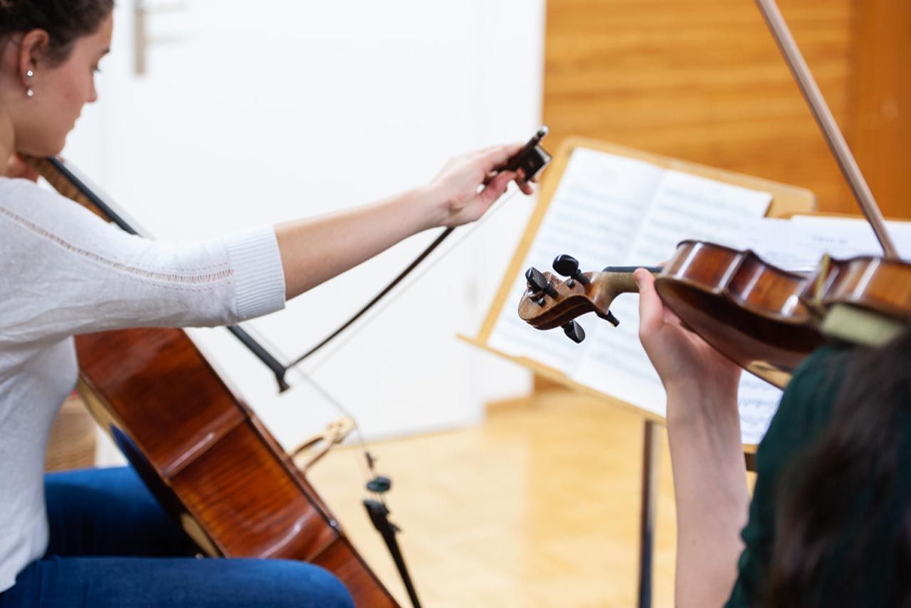 Blick über die Schulern einer Cellistin und einer Violinistin