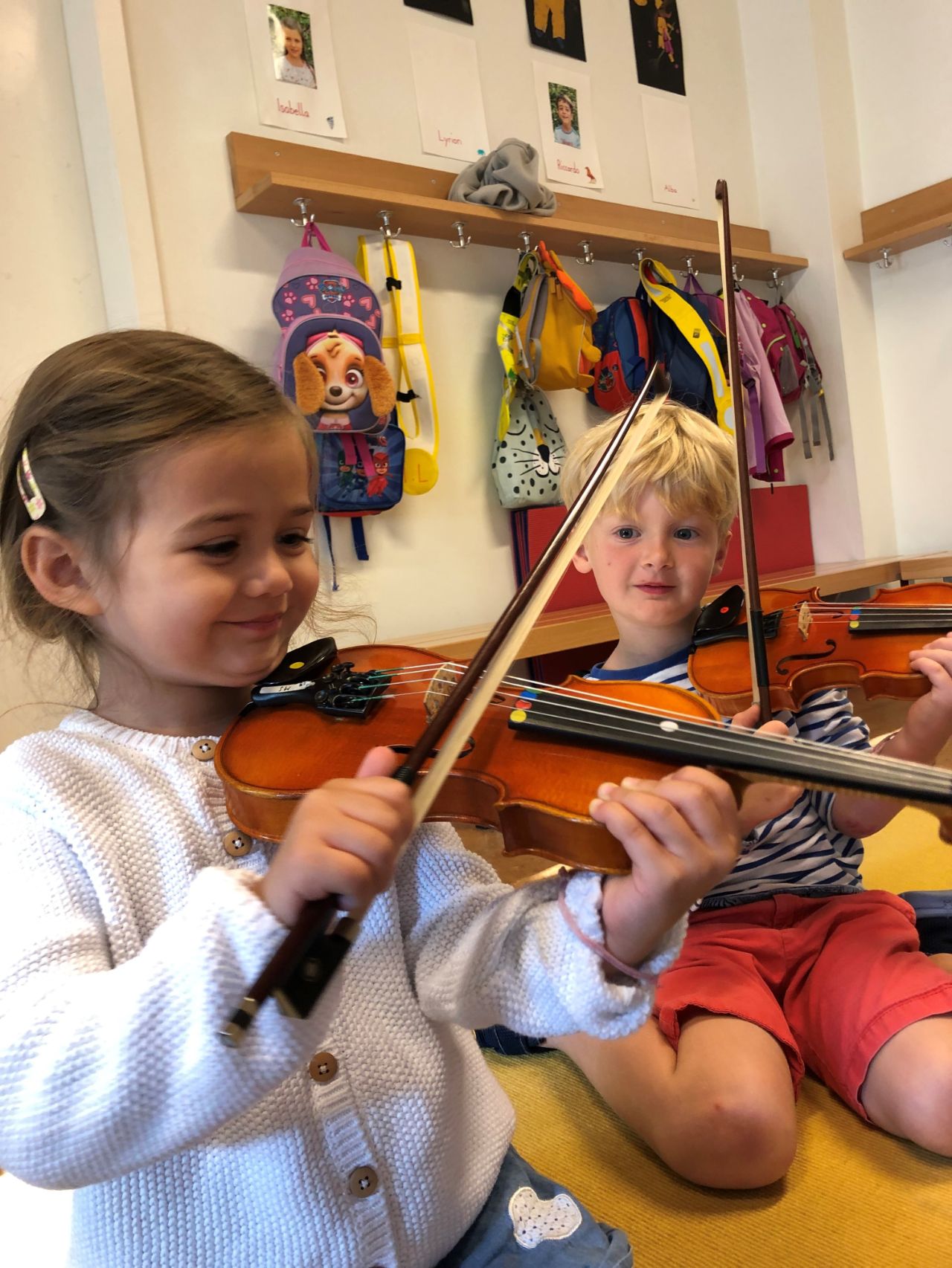 Zwei kleine Kinder spielen Geige